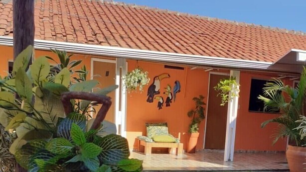 A rustic outdoor seating area with a wooden cat house planter, a bench, and a sign reading "Paz". - Pousada Beira Rio  (Bonito)