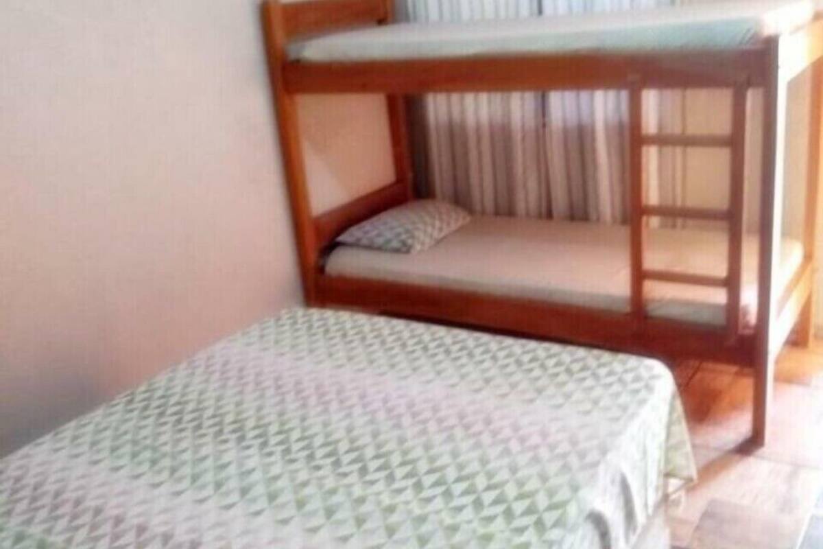 A room with a bunk bed and a single bed, both with patterned bedding.
