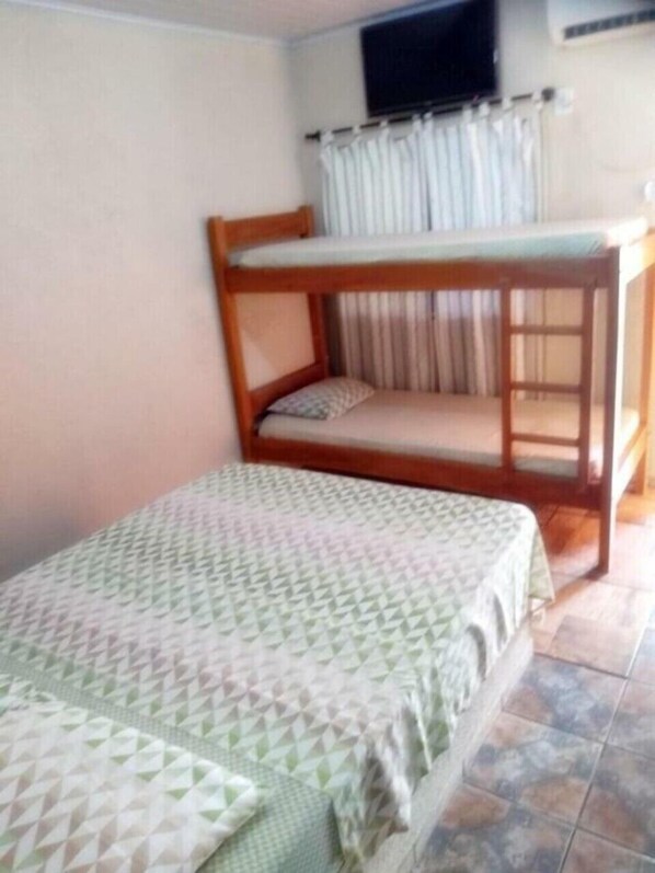 A room with a bunk bed and a single bed, both with patterned bedding.