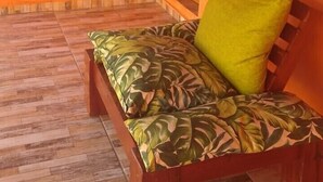 A room with a wooden bench and a green cushion, orange walls, and a wooden floor. - Pousada Beira Rio  (Bonito)