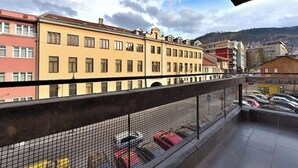 A balcony with a view of colorful buildings and parked cars. - BASC Modern 2 (Sarajevo)