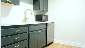A kitchen with dark cabinets, a gold faucet, a microwave, and a dishwasher. - Quiet home tucked between Crystal River & Rainbow River (Crystal River)