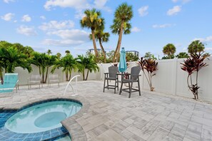 A pool area with a hot tub, lounge chairs, and a table with chairs. - 🌊Anchors Down | Luxury 5BR w/ Private Pool, Spa + Game Room | Steps 2 Beach🏖️ (Fort Myers Beach)