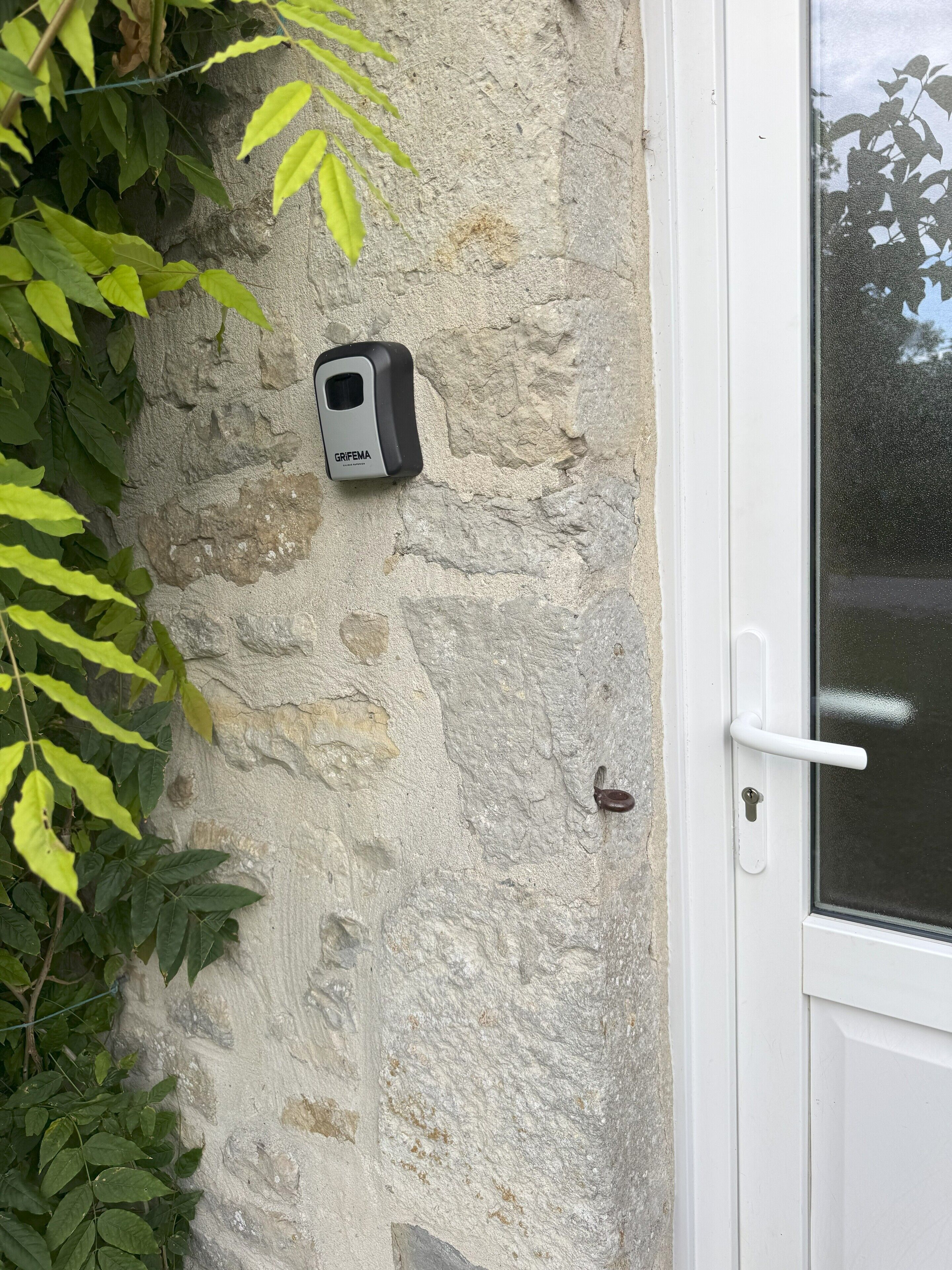 A door with a white handle and a textured stone wall.