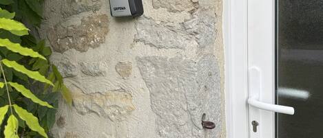 A door with a white handle and a textured stone wall.