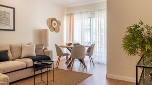 Un salon comprenant un canapé, une table basse et un coin repas avec des chaises et une table.