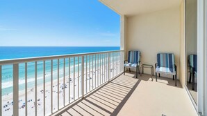 A balcony with a view of the beach and ocean.