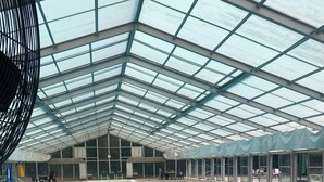 Una piscina interior con techo de cristal, agua clara y un cartel que dice 'NO DIVING' en el borde de la piscina.