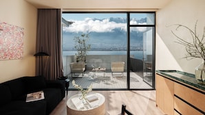 A modern living room with a large sliding glass door leading to a balcony with a city and mountain view. - Yunnan Hills&Harmony Retreat Dali Erhai (Dali)