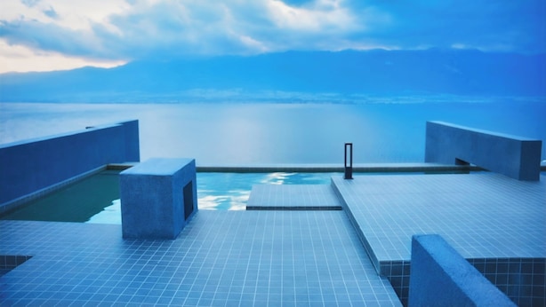 A rooftop infinity pool with a clear view of the ocean and mountains in the distance. - Yunnan Hills&Harmony Retreat Dali Erhai (Dali)