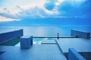 A rooftop infinity pool with a clear view of the ocean and mountains in the distance. - Yunnan Hills&Harmony Retreat Dali Erhai (Dali)