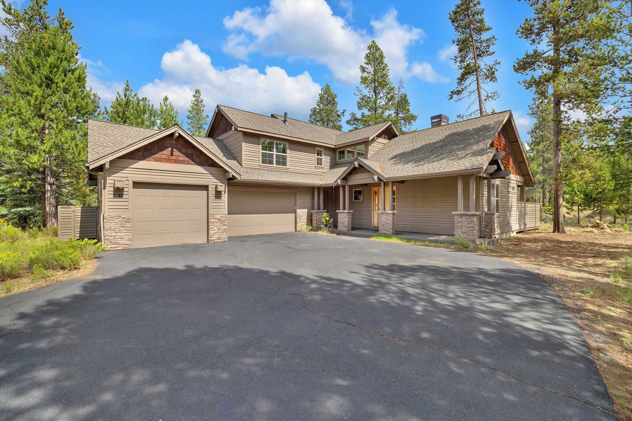 A two-story house with a garage, a covered porch, and a driveway.