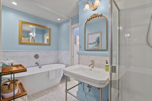 Une salle de bain avec une baignoire, un lavabo et une douche.