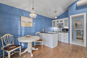 Une cuisine avec un îlot central, des meubles blancs et un mur bleu.