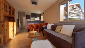 A modern living room with a sofa, a coffee table, and wooden cabinets. - Wifi, 1st floor, balcony, parking, tv, ski locker, 44m², Le Grand Bornand (Le Grand-Bornand)
