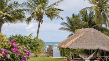 Na praia, areia branca, espreguiçadeiras, guarda-sóis