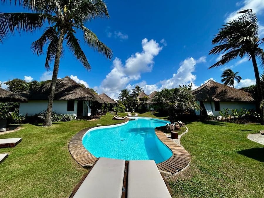 Una piscina al aire libre, sombrillas, sillones reclinables de piscina