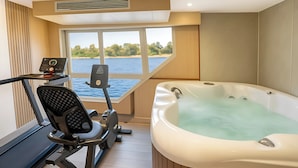 A bathroom with a bathtub, exercise equipment, and a window overlooking a body of water. - Nile Cruise Rene, Every Wednesday from Aswan for 3 nights and every Saturday from Luxor for 4 nights, including three meals (Aswan)
