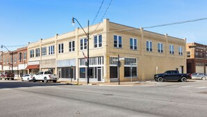 A multi-story building with a flat facade, large windows, and a corner entrance. - Apartment 2: Okmulgee Main St (Okmulgee)