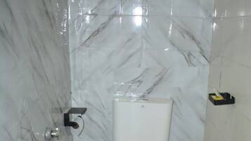 Chuveiro, toalhas de banho, sabonete, papel higiênico