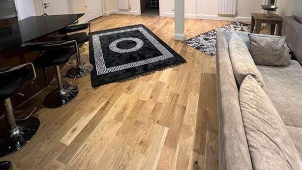 Un soggiorno moderno con un divano, un tavolino, un pianoforte e un tappeto decorato.