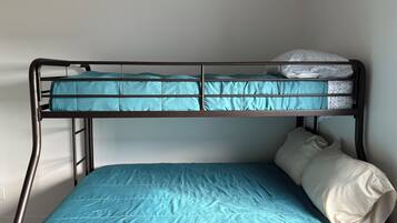A bunk bed with a blue mattress and a white pillow.