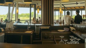 A restaurant with a high wooden ceiling and large windows offering a view of the outdoors. - Exceptional apartment with a view of the golf course and beach—a 3-minute walk away (Grand Baie)