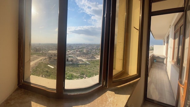 A room with large windows offering a view of a cityscape. - Armena - Nork Marash (Yerevan)