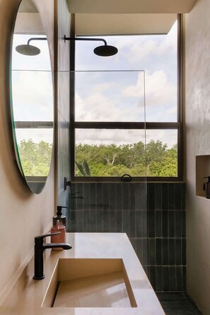 A modern bathroom with a large window, a rectangular sink, and a shower area.