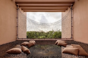 A room with a view through a window, a hammock, and a patterned floor.