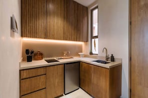 A modern kitchen with wooden cabinets, a built-in dishwasher, and a window above the sink.