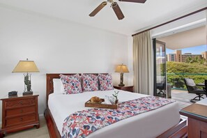 A hotel room with a bed, two bedside tables, a ceiling fan, a balcony with a view, and a window with curtains. - Honua Kai | Ocean View 5 BR, Sleeps 14 | Car Incl. w/ 6+ Nights | HKK ML-1403 by KBM (Lahaina)