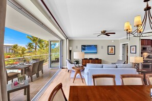 A modern hotel room with a balcony, dining area, living room, and kitchen. - Honua Kai | Ocean View 5 BR, Sleeps 14 | Car Incl. w/ 6+ Nights | HKK ML-1403 by KBM (Lahaina)