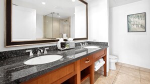 Une salle de bain moderne avec deux lavabos, un grand miroir et des toilettes.