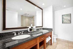 Ein modernes Badezimmer mit zwei Waschbecken, einem großen Spiegel und einer Toilette.