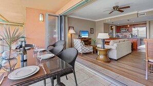 Amplia sala de estar con una mesa de comedor, un sofá, un televisor y una zona de cocina.