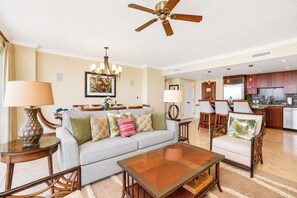 A hotel room with a living area, dining area, and kitchen.