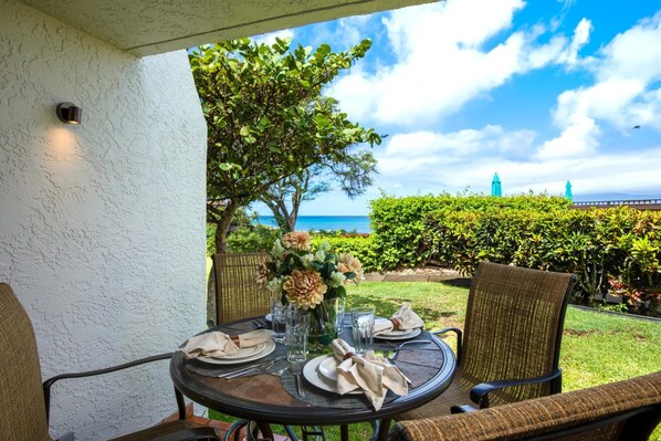 Une table dressée à l’extérieur, avec vue sur l’océan et sous un ciel dégagé.