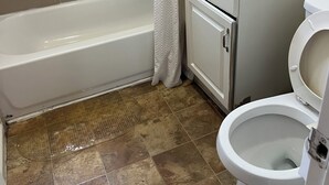 Ein Badezimmer mit Badewanne, Toilette, Waschbecken und Spiegel.