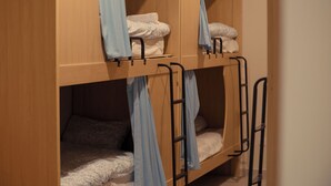A bunk bed room with wooden walls and metal railings. - Rox Madrid Shared room (Madrid)