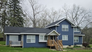 A two-story house with a front porch and a small deck. - New Renovation: 5BR Lake Delavan Retreat, Fire Pit, Huge Yard, Lake Access (Delavan)