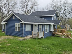 A two-story house with a front porch, a small deck, and a garage.