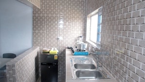 Una cocina compacta con refrigerador, pileta y ventana.