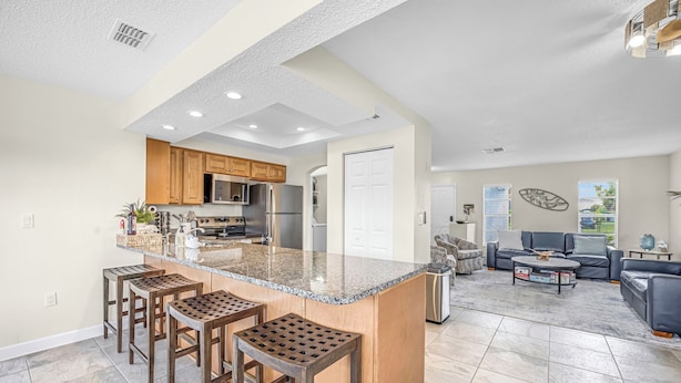 A spacious kitchen with a large island, wooden bar stools, and modern appliances. - SCALLOP TIME AT WATERFRONT ESCAPE DIRECT GULF ACCESS, GOLF CART & KAYAKS. (Hernando Beach)