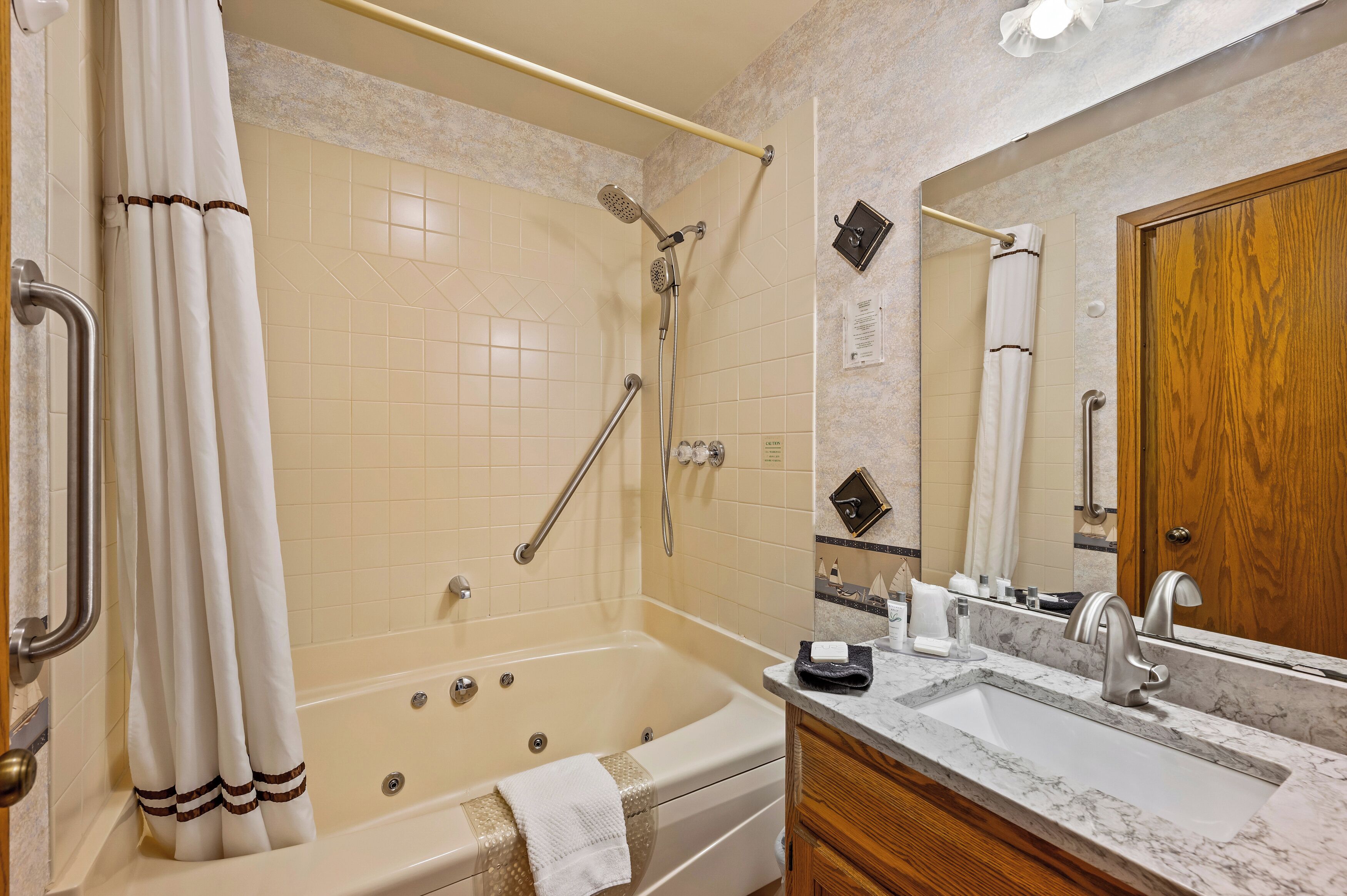 A bathroom with a bathtub, shower, and sink.