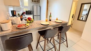 A modern kitchen with a central island, bar stools, and a dining area. - Modern Apartment with Ocean View and Heated Swimming Pool (La Serena)