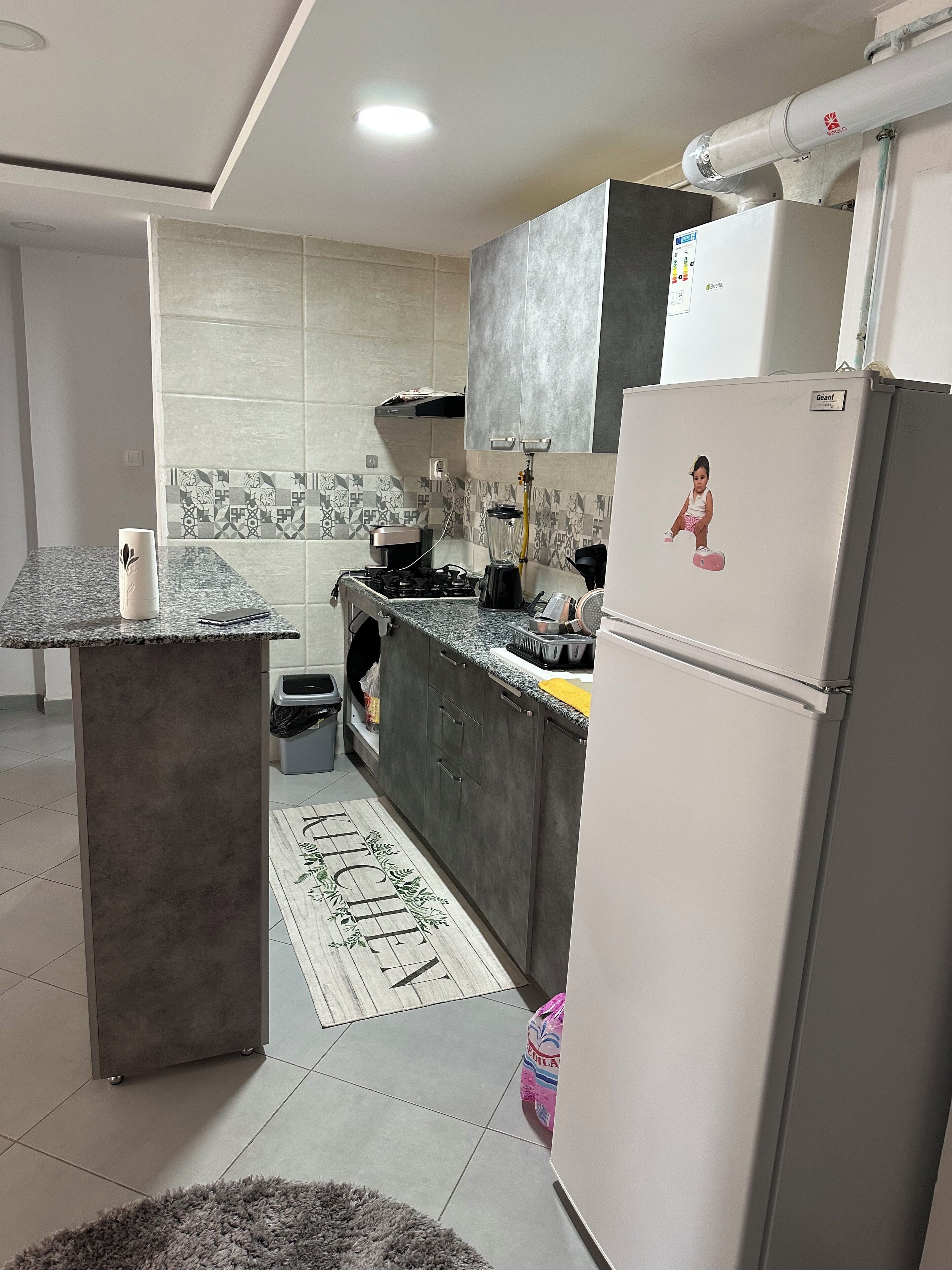Una cocina moderna con estufa integrada, refrigerador y microondas.