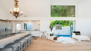 A modern kitchen with a central island, stainless steel appliances, and a chandelier. - Kenwood Lodge - 5 Bedroom/En-suite, Heated Pool (Kenwood)