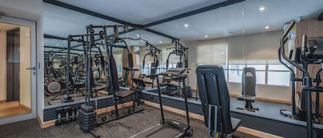 A gym with various exercise equipment, a mirror, and a treadmill.