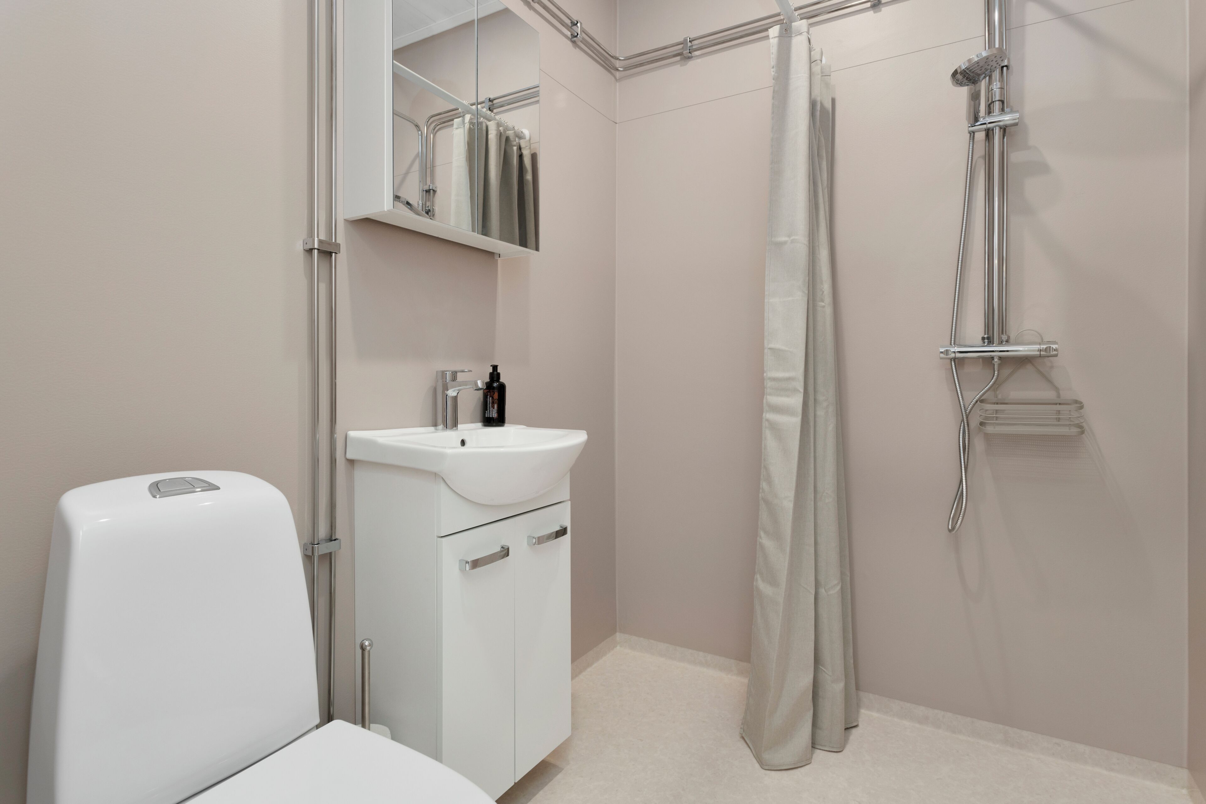 A modern bathroom with a toilet, sink, and shower.
